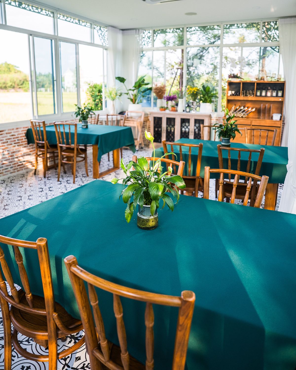 The WIROON dining room, several tables laid in teal linen beneath large windows