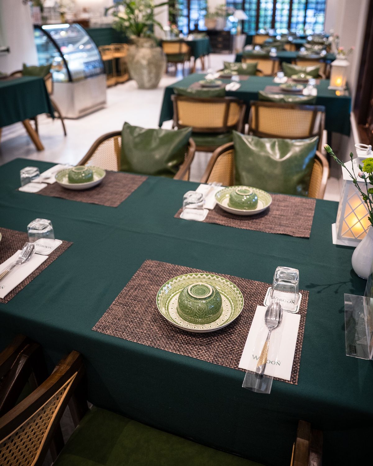 A laid dining table at WIROON with teal linen and place settings