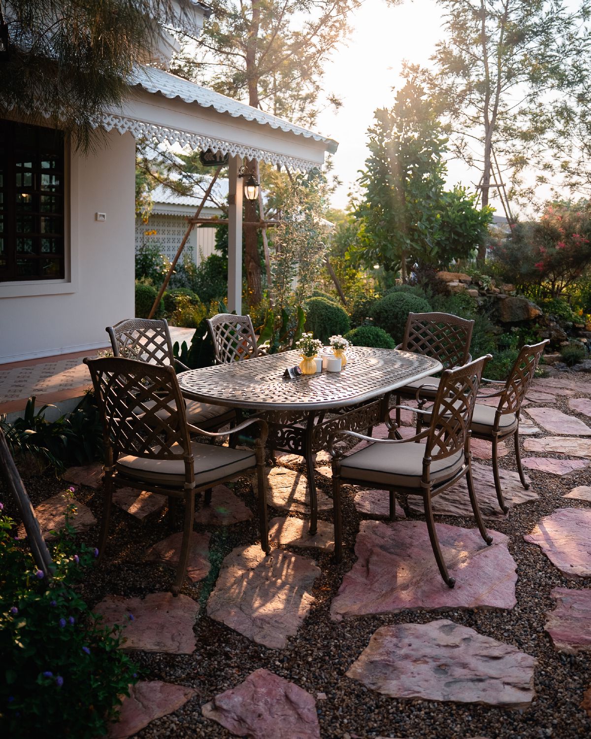A garden terrace at WIROON with a table set for guests among trees and planting